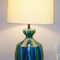 Substantial Mid-Century Studio Stoneware table lamp.  
The lamp features glazed abstract blue striped monochromatic palette. 

The lamp is in overall EXCELLENT vintage condition. There are no chips, no cracks and no repairs to the stoneware vessel. There is some typical light wear to the spun brass base and wood vase cap.  Overall the lamp presents exceptionally clean.
This lamp was most likely produced in the late 60s / early 1970s.

This is a heavy lamp, weighing in at appx 14 lbs. unpacked

The electric componets have been inspected and the lamp is in good working order. The double cluster socket assembly allows for 3 levels of light when two bulbs of differing wattages are used. The cord is still pliable with no apparent cracking or exposed wire.

Dimensions:

appx 30" (overall height)

8" diameter (spun brass base)

10.5 diameter x 14" high (vessel alone)

_____________________________________________________________________

***No shade is included. The shade seen is for display purposes only. On buyers request, direction will be provided on where shade of the same dimensions can be purchased.

15" x 16" x 11" slant (display shade dimensions)