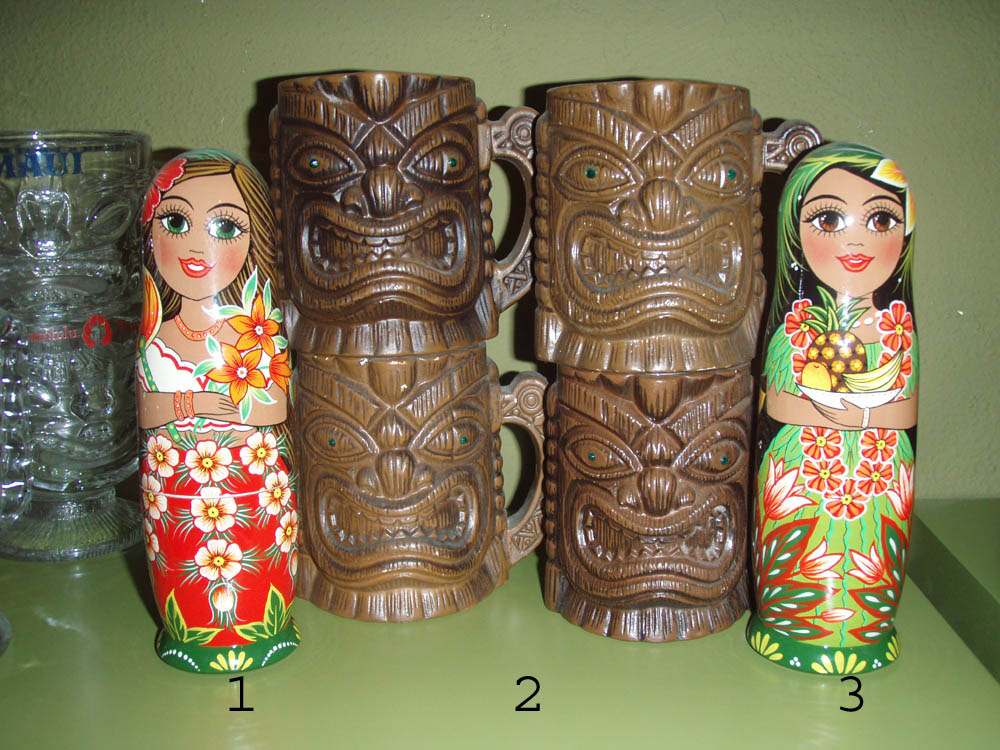 These HULA DOLLS were created in  ST. PETERSBURG, RUSSIA by Matryoshka artists. 
1. Hula Girl with Pineapple Bowl  7"H, $25.00, 

2. Tiki Mug w/handle(coffee mug style) and emerald green eyes (4 available) $30.00
 
3.Hula Girl with Birds of Paradise Fan  7"H, $25.00,
